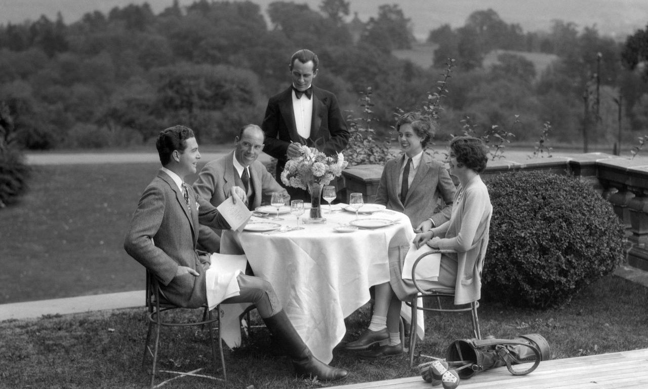 Gente elegante comiendo en una mesa al aire libre