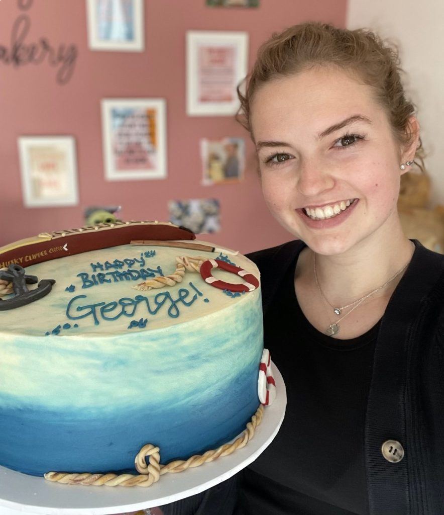 La joven repostera con la tarta de cumpleaños que preparó para George Clooney.